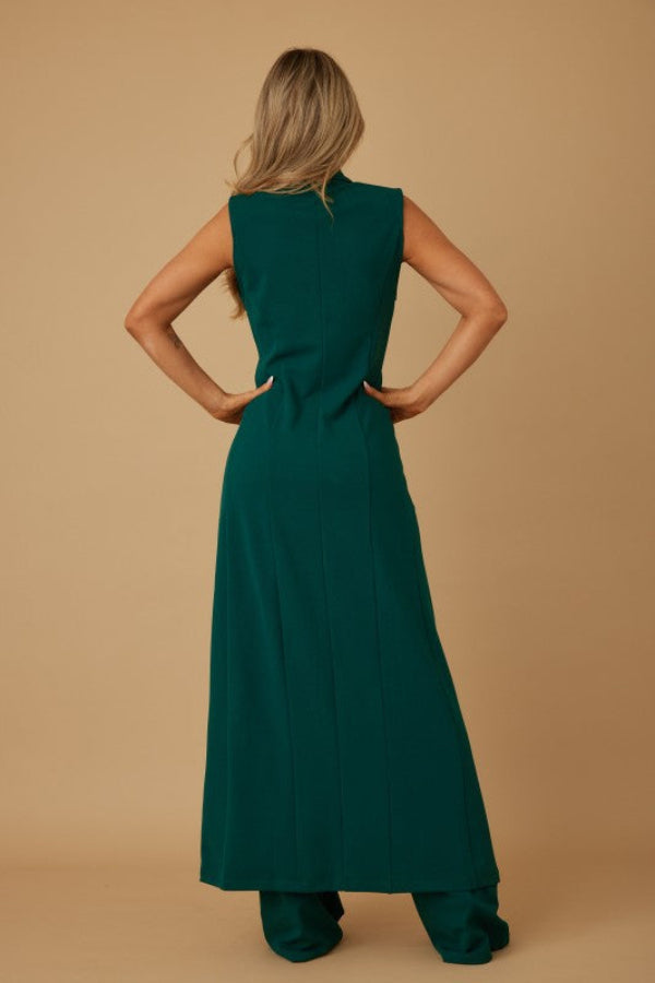 Woman wearing a green dress against a beige background